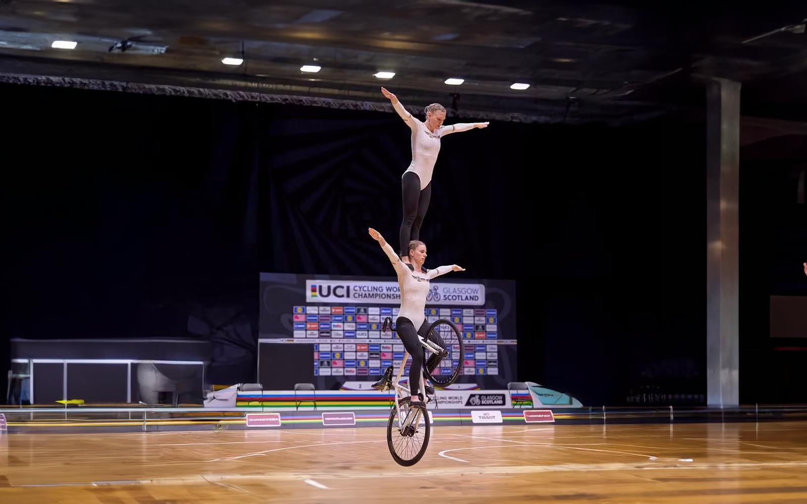 Zwei Athleten balancieren auf einem Fahrrad