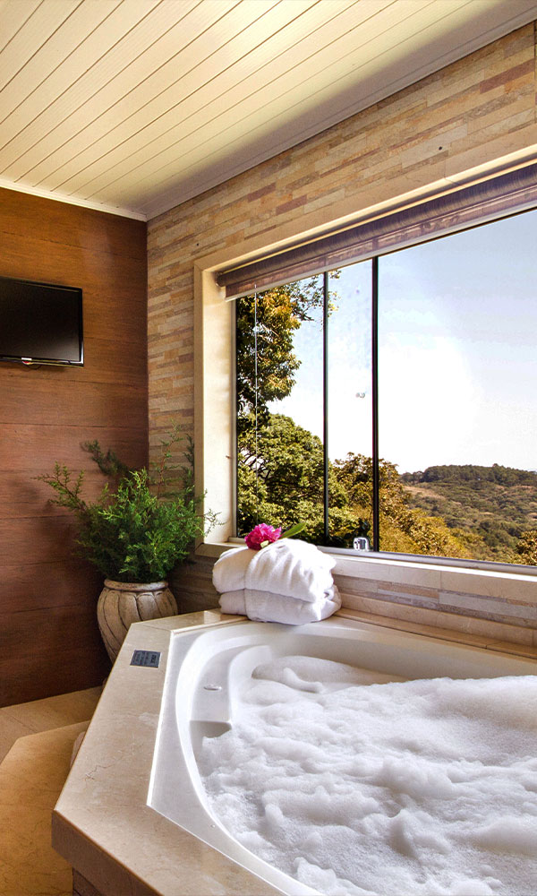 Banheira em suíte de quarto de pousada