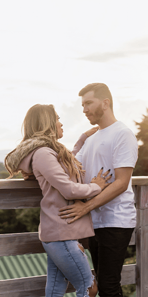 Casal se olhando em deck com vista para as montanhas