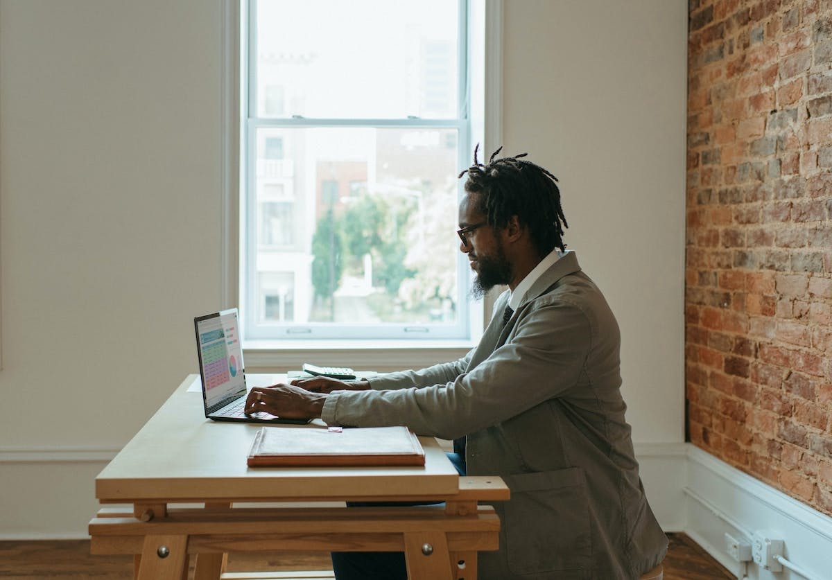 Man working on laptop from minimalist coffeeshop interior