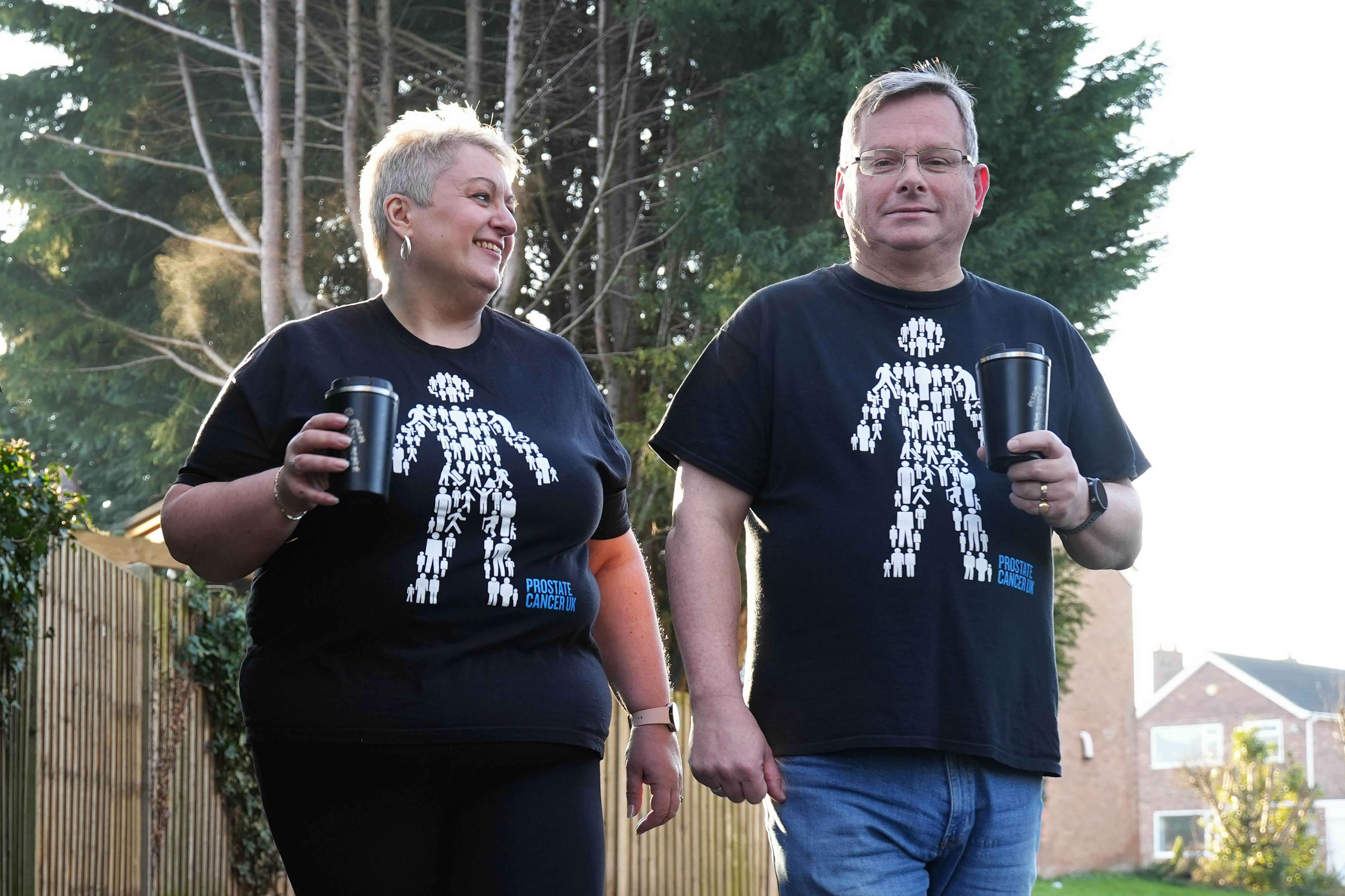 A man and woman wearing Man of Men t-shirts