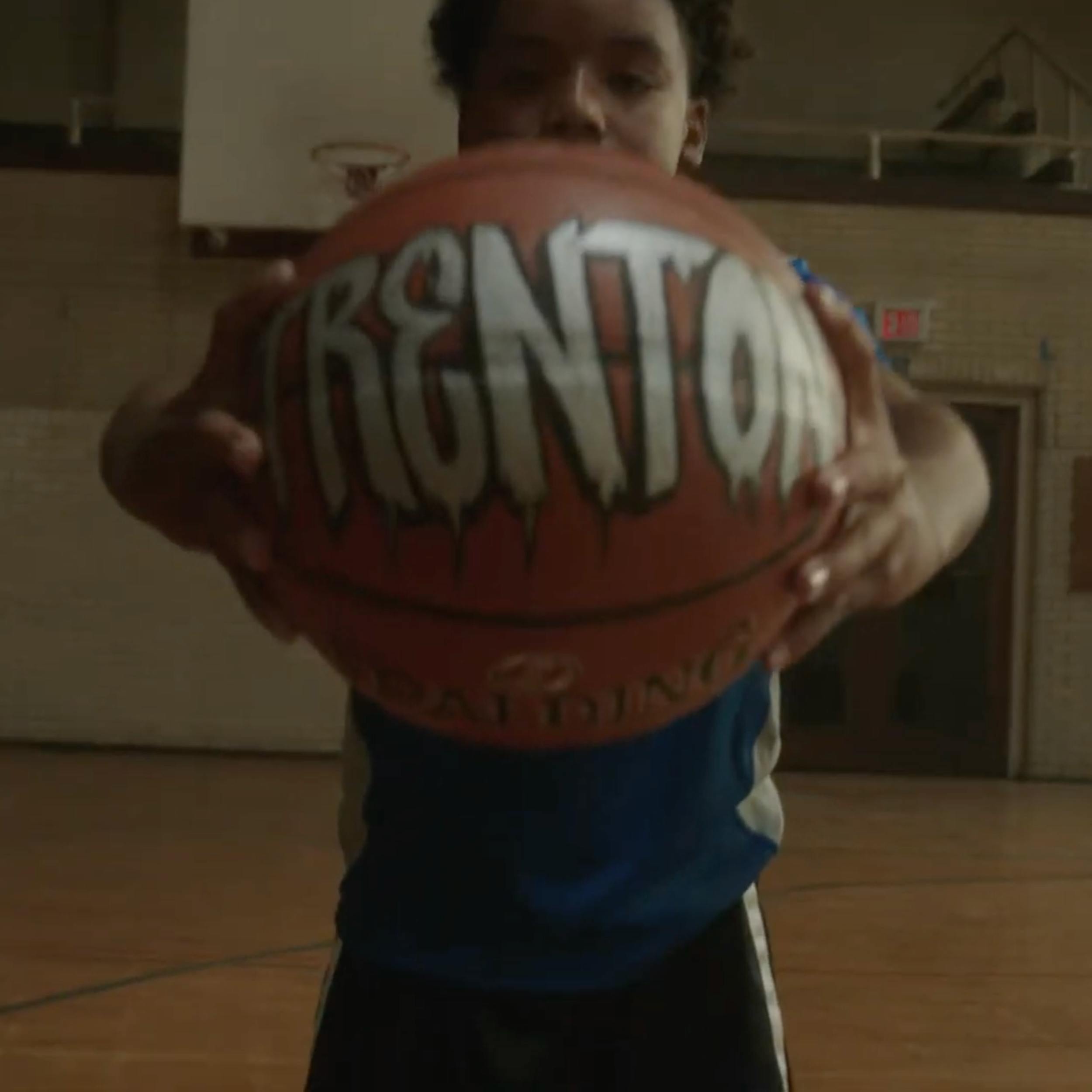 A boy holding a basketball with the text: Trenton