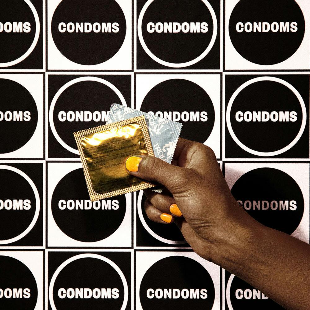 A hand holding a couple condom package