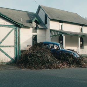 A car parked outside of a white house