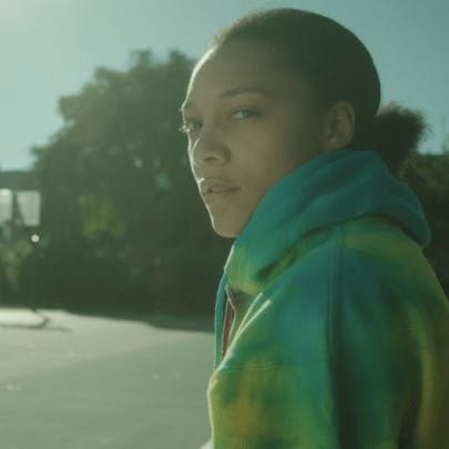 A woman wearing a hoodie looking back