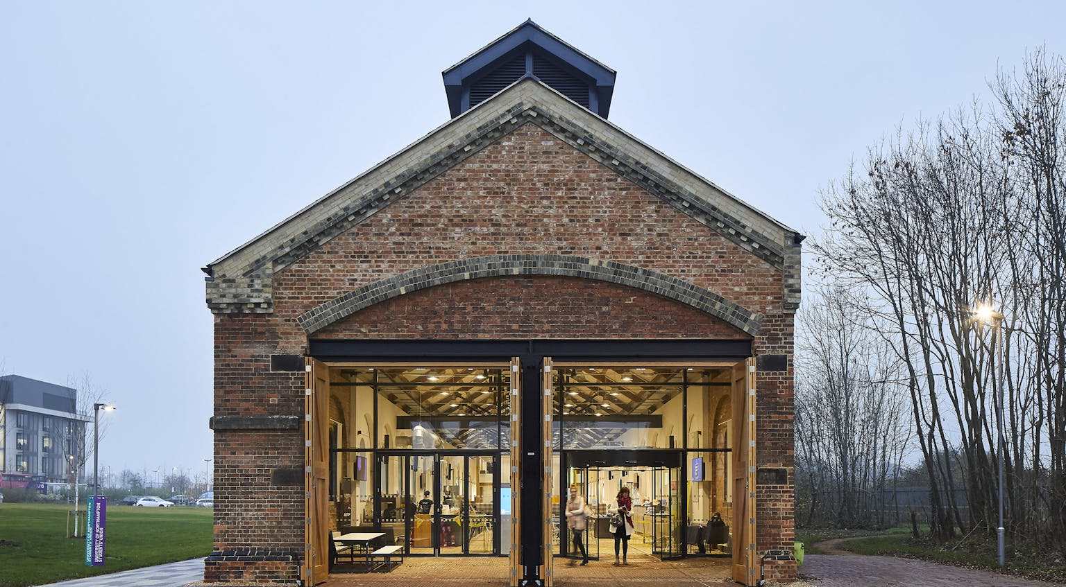 Brick Victorian engine shed converted into glass fronted contemporary hub
