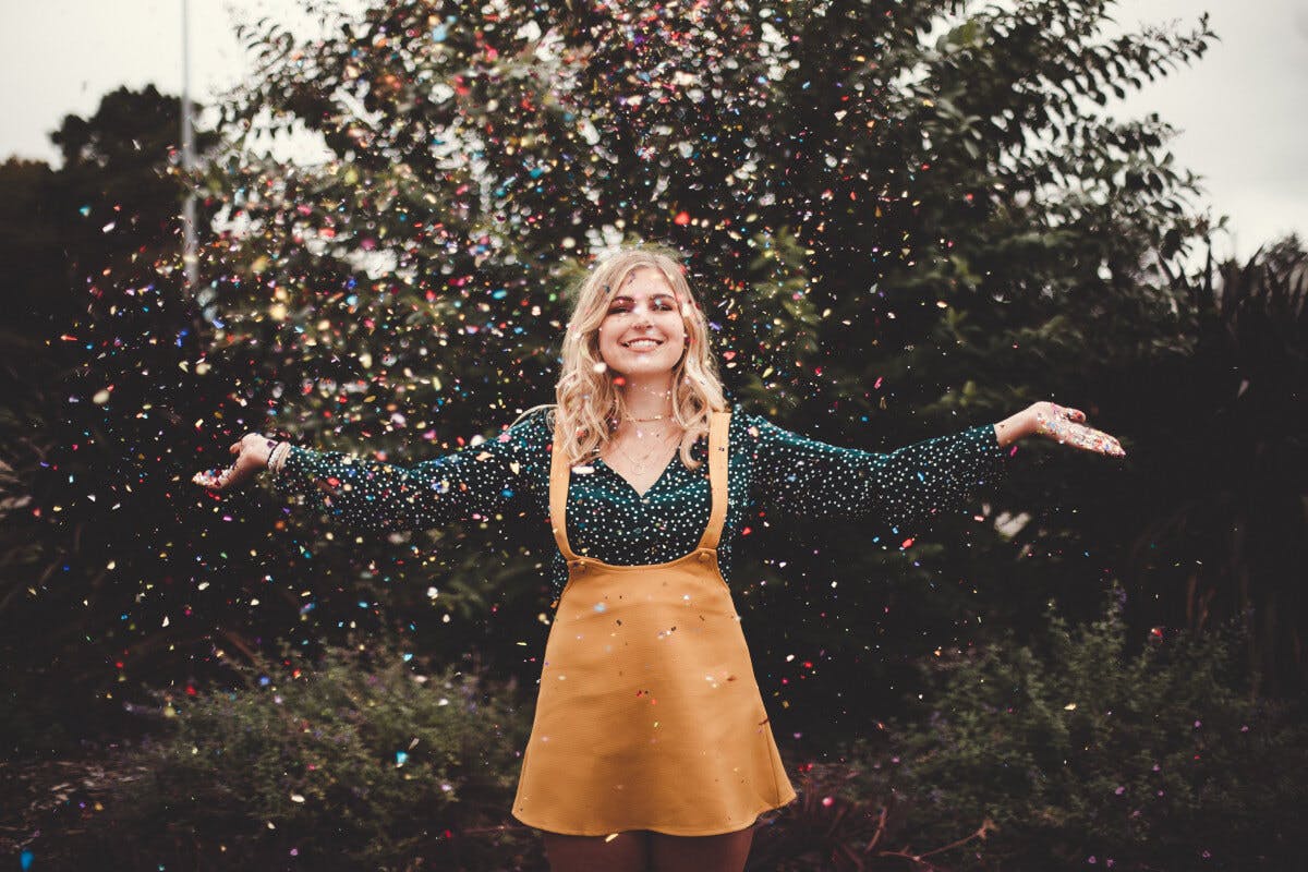 Positiv denken: Glückliche Frau wirft Confetti