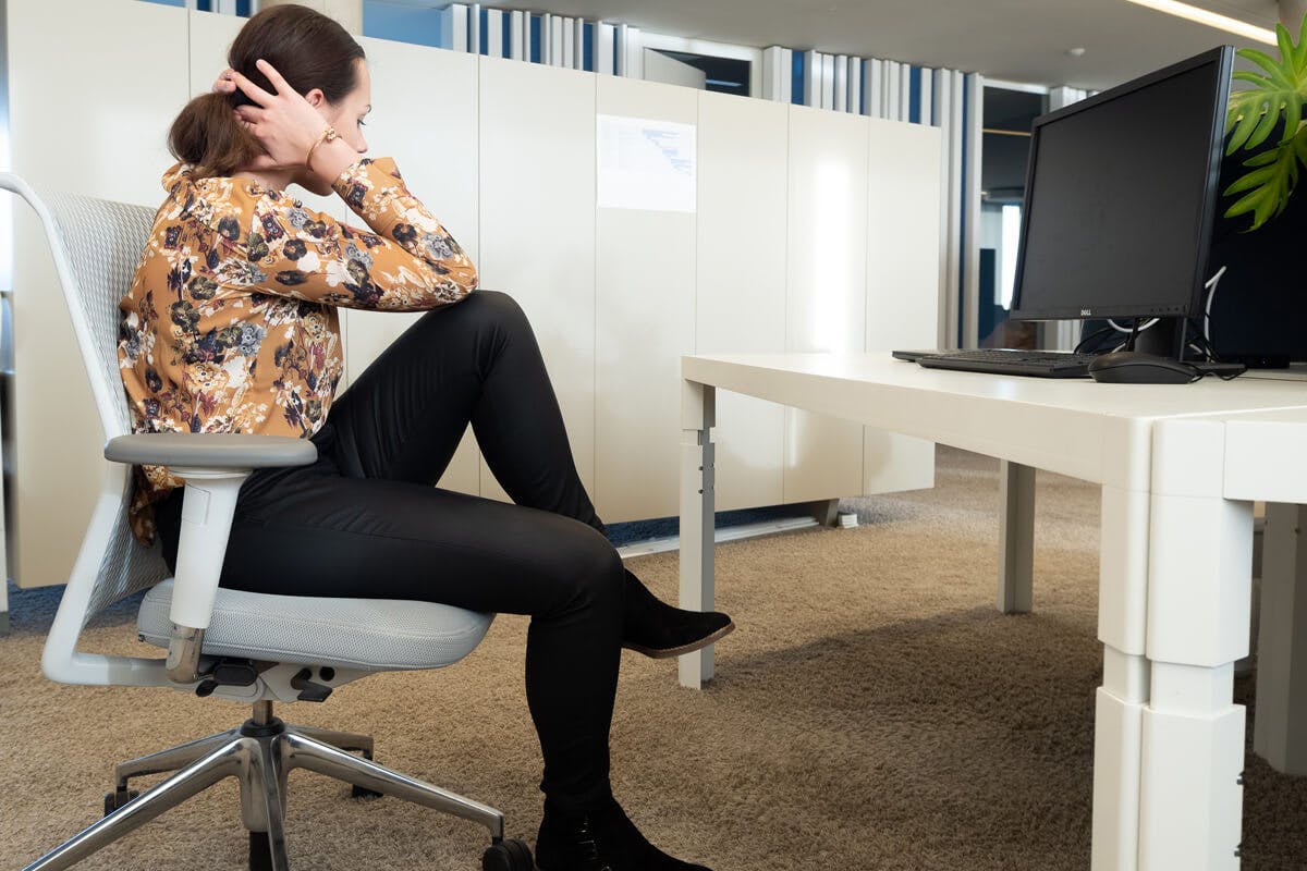 Frau macht Bauchmuskel-Training am Schreibtisch