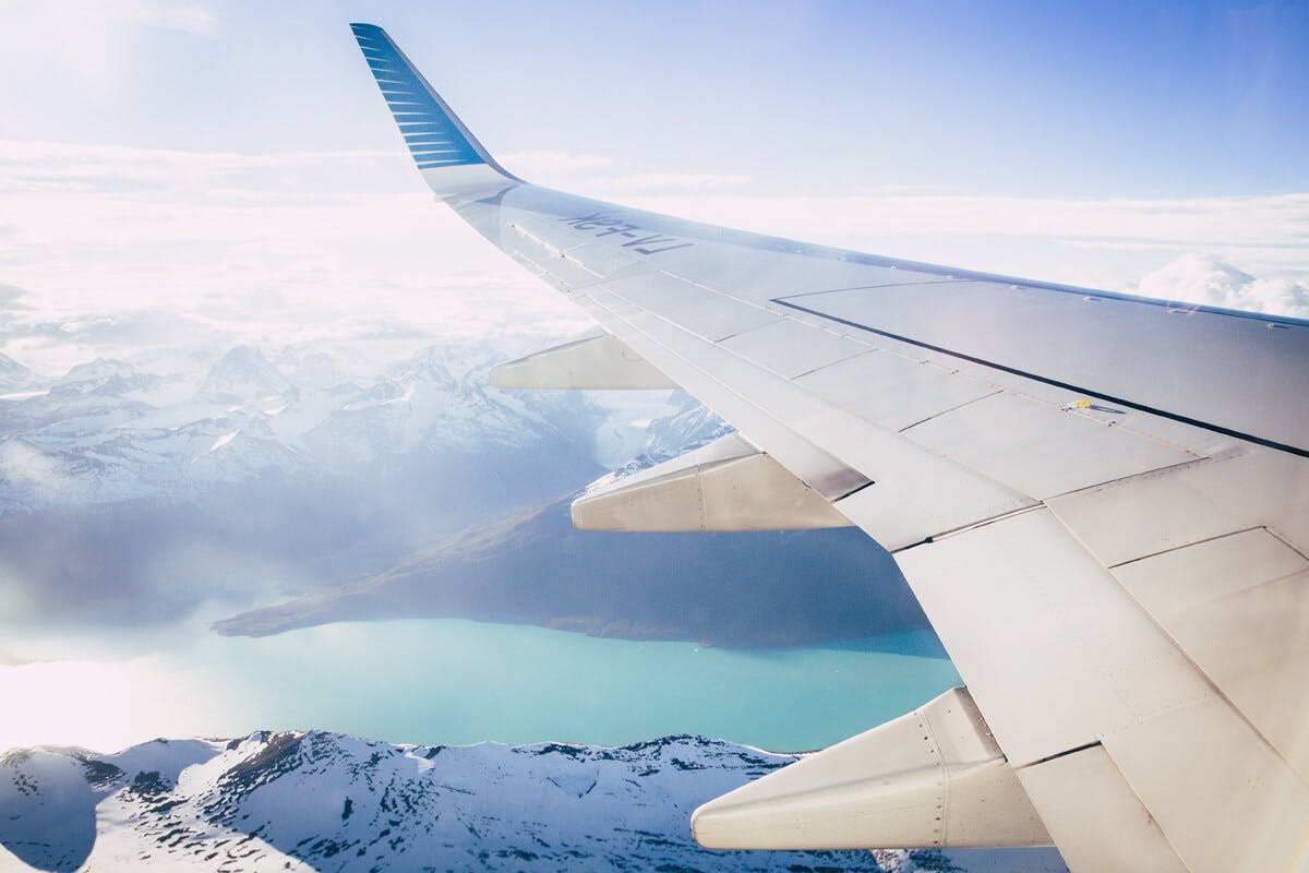 Flugzeug-Flügel über den schneebedeckten Alpen