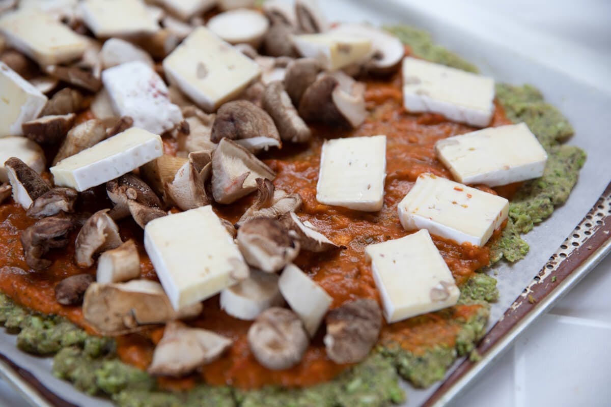 Fertig belegte Pizza mit Champignons und Camembert.