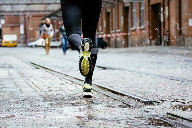 Läufer auf der Straße im Regen