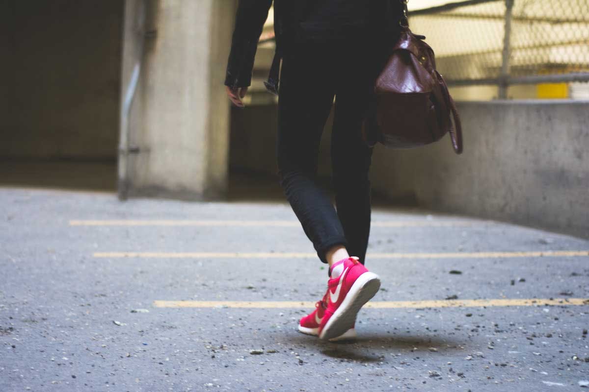 Frau in pinken Schuhen geht zu Fuß