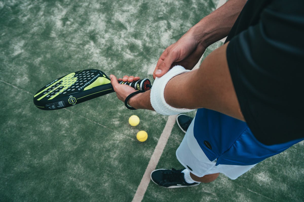 Muskelkater - oder die Tage danach. Mann hält Tennisschläger.