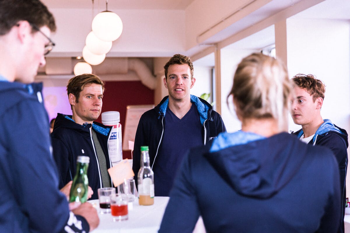Fünf Pure Athleten unterhalten sich.