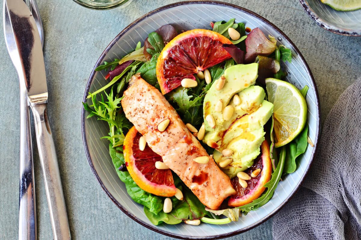 EIn Fischgericht mit Salat, Avocado und Blutorange