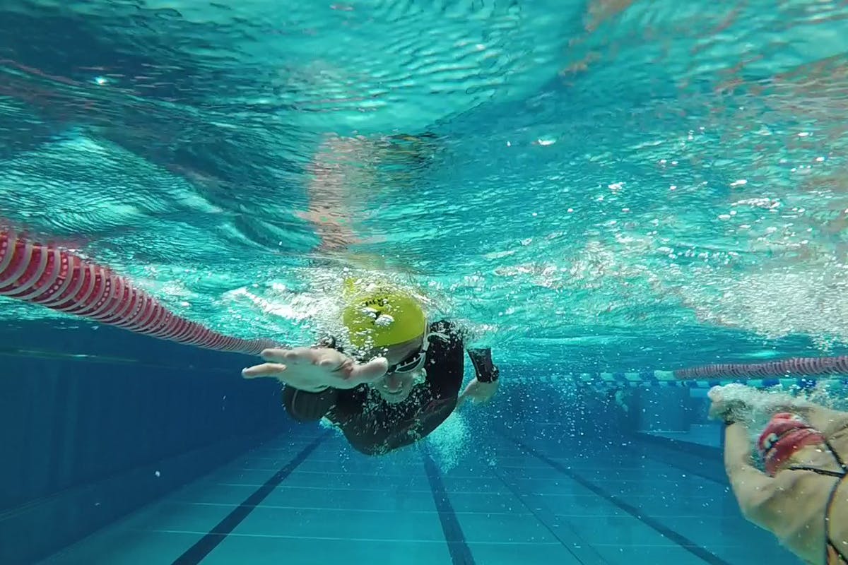 Triathlon Camp Tagebuch Schwimmer im Becken mit ausgestreckter Hand