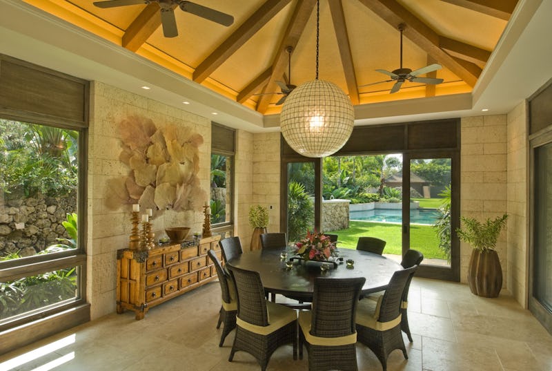 Interior photo of dining area with large windows looking at pool and yard