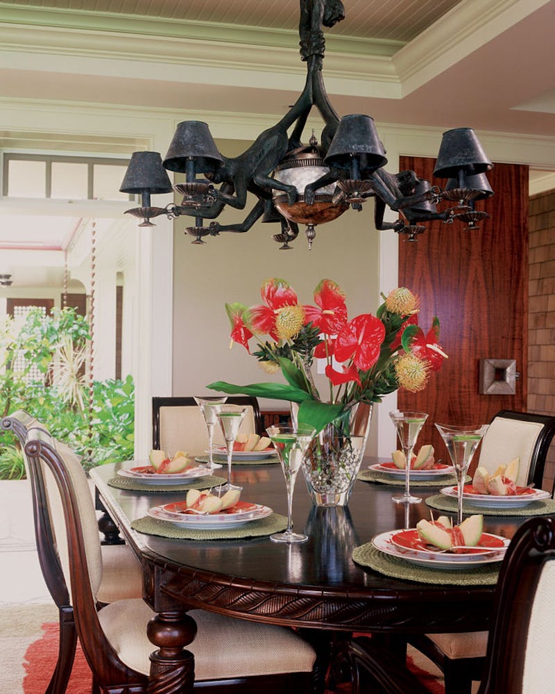 Dining area with chandelier and floral centerpiece.