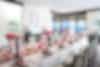 Reception room with long table filled with pink and white roses
