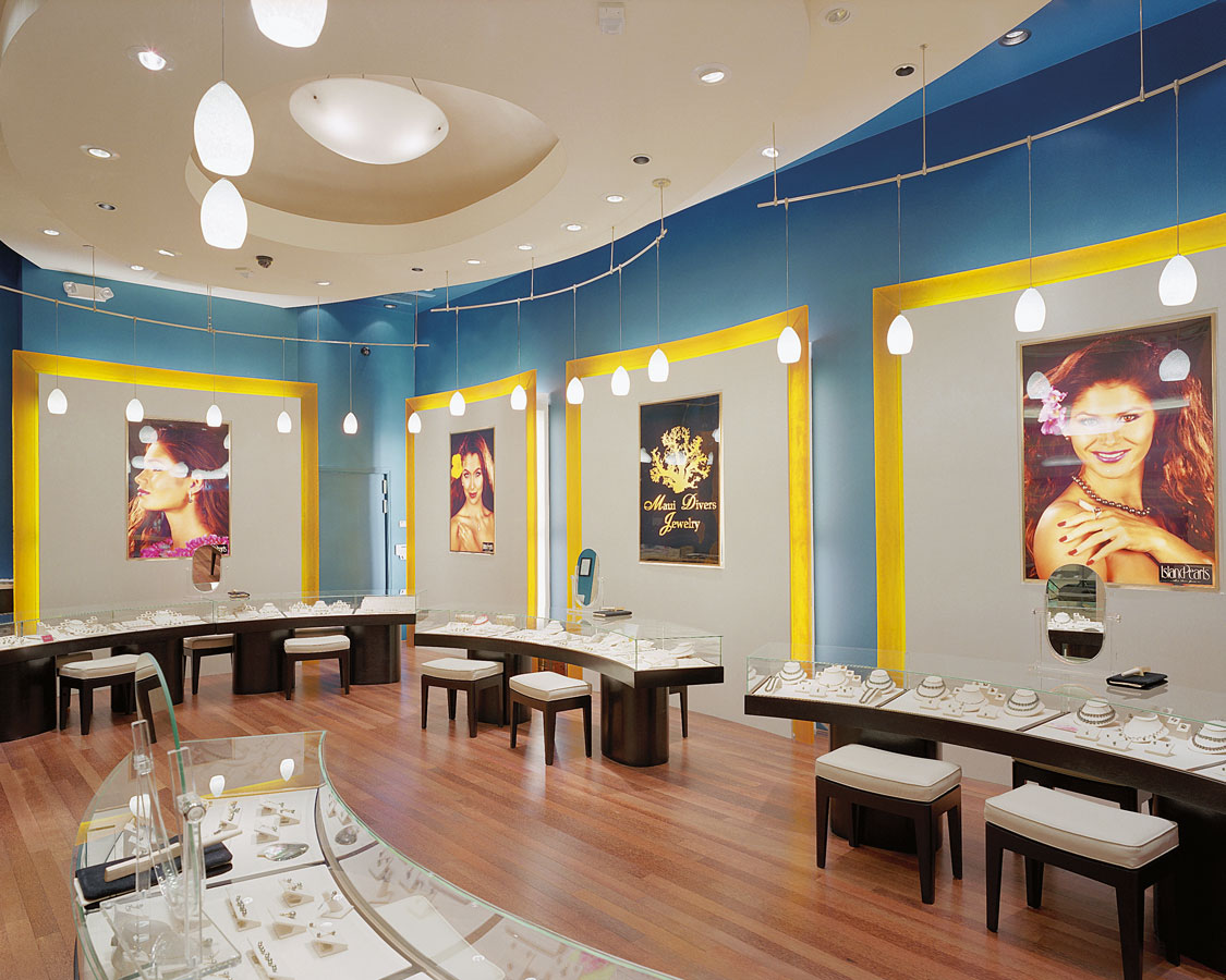 Photos on walls behind display cases at Island Pearls Las Vegas