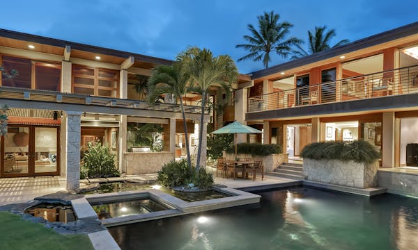 Exterior photo of house with pond at dusk