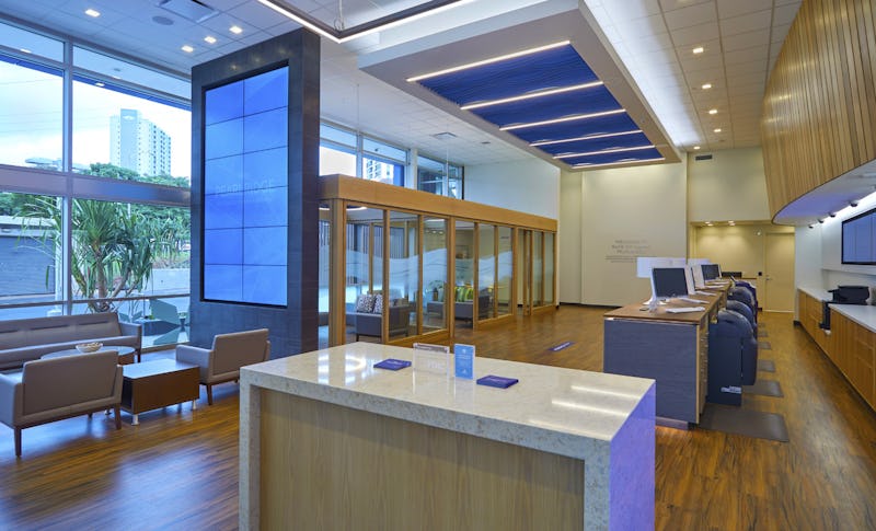 Interior shot of Bank of Hawaii at Pearlridge showing wood floors, modern lighting, and glass conference rooms