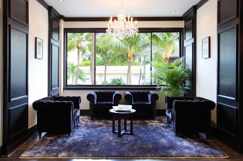 Room with dark velvet chairs and a chandelier