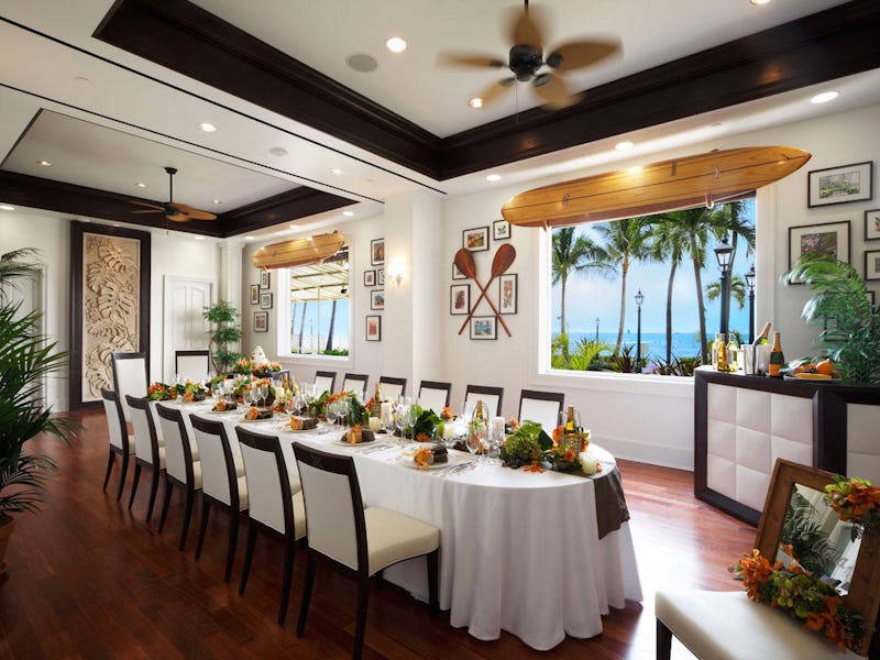 Upscale reception room with surfboards, paddles, and long table.