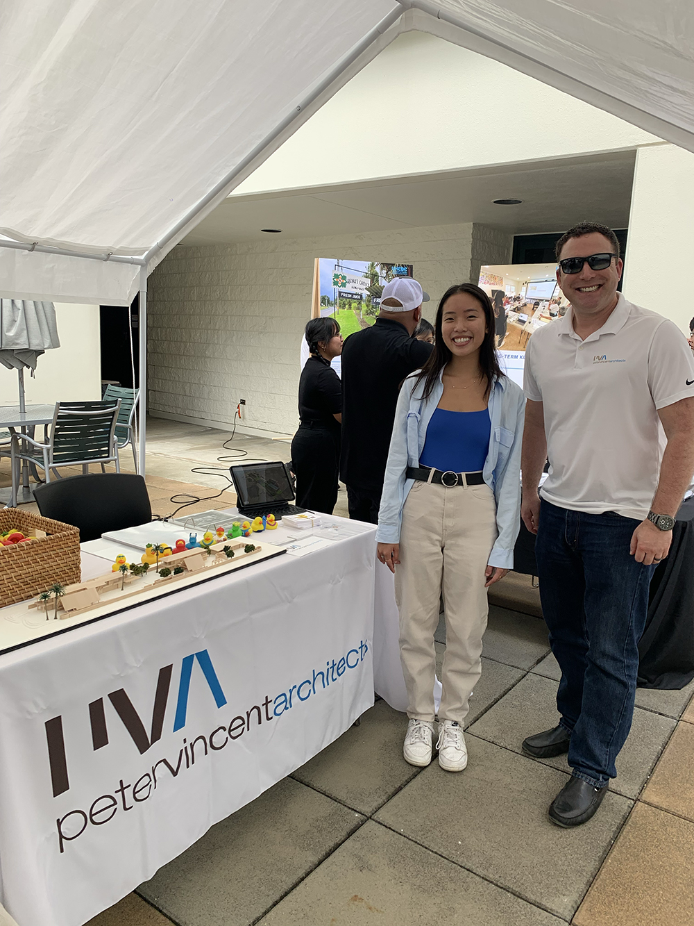 Todd and Tryphena stand next to table display at Career Fair