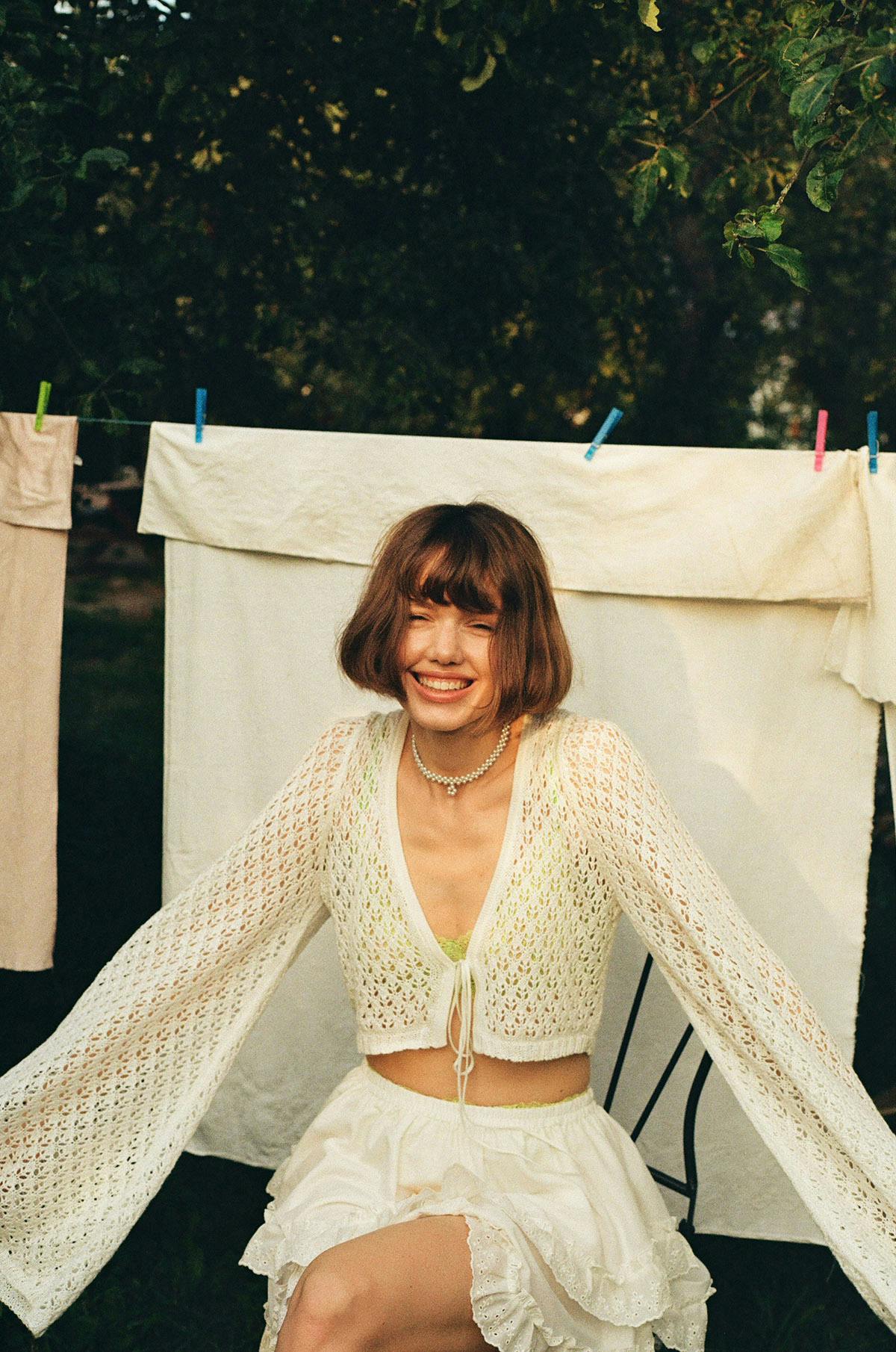 Film photography young woman in white in front of washing line
