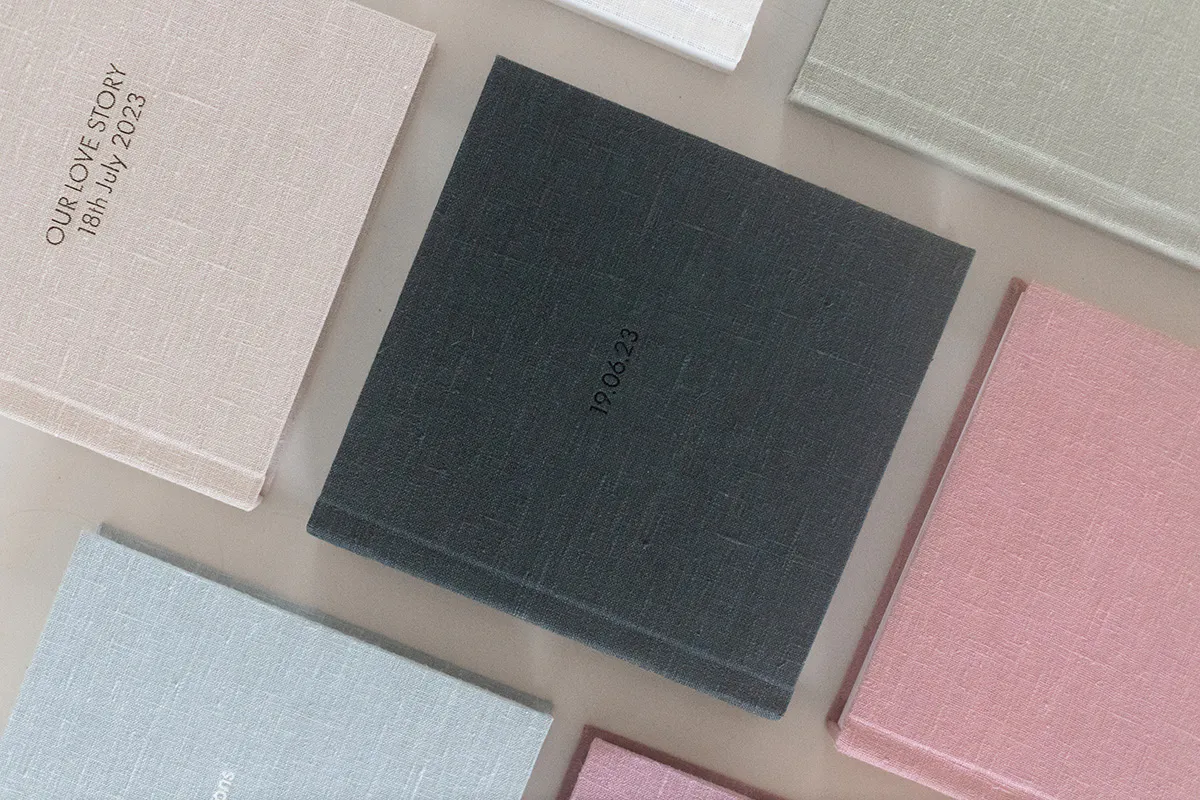Pastel linen Kiss Books album covers with embossed titles including Our Love Story.