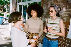 Three employees having coffee outside 