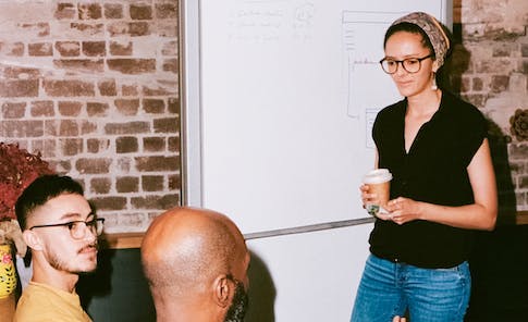 three team members meeting in front of a whiteboard