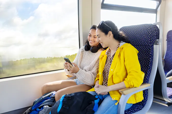 two people in a train looking at a phone
