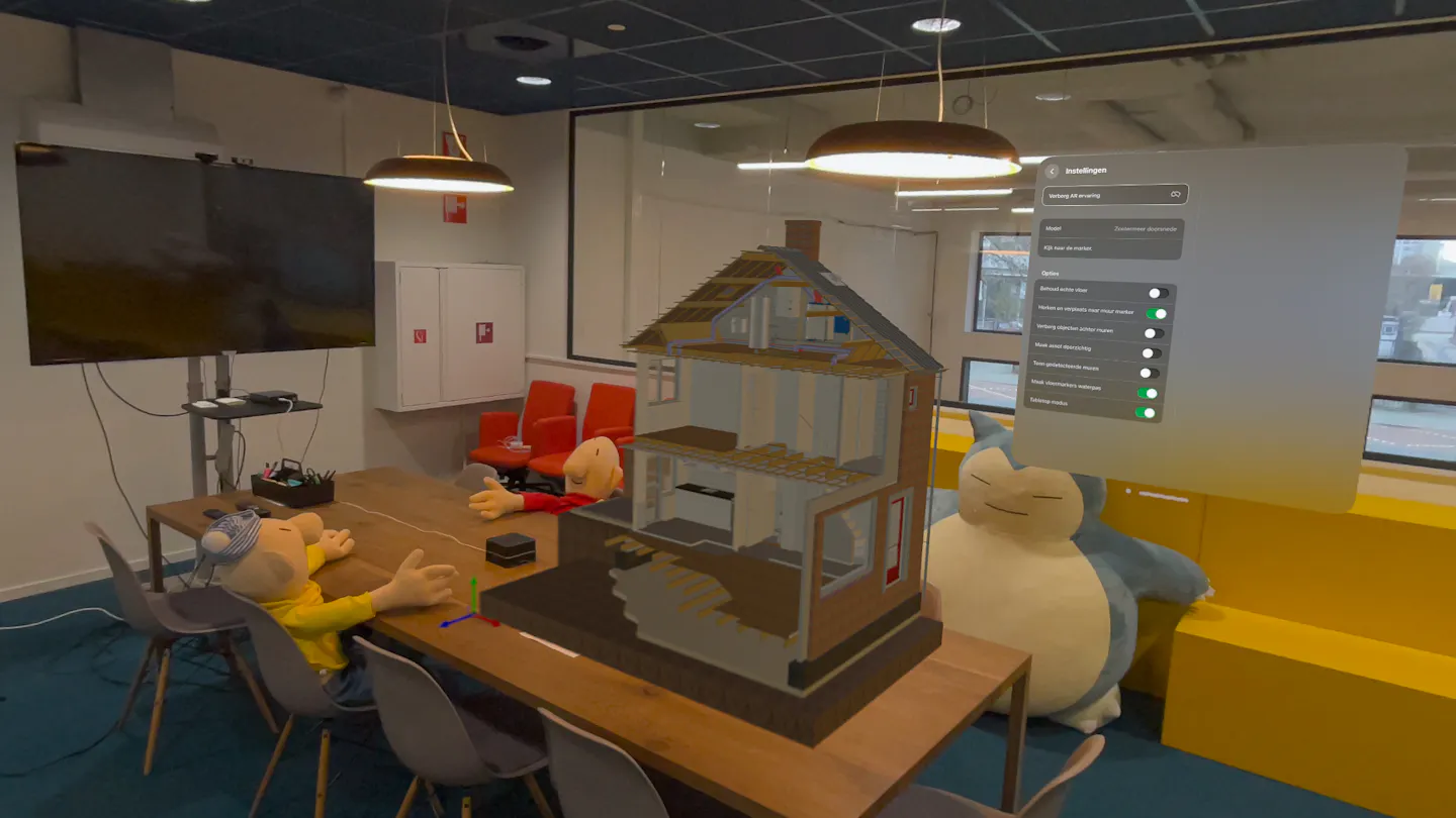 A meeting room with a virtual house placed inside. The house is small in size, and the menu of the Mark app is visible, viewed with Apple Vision Pro