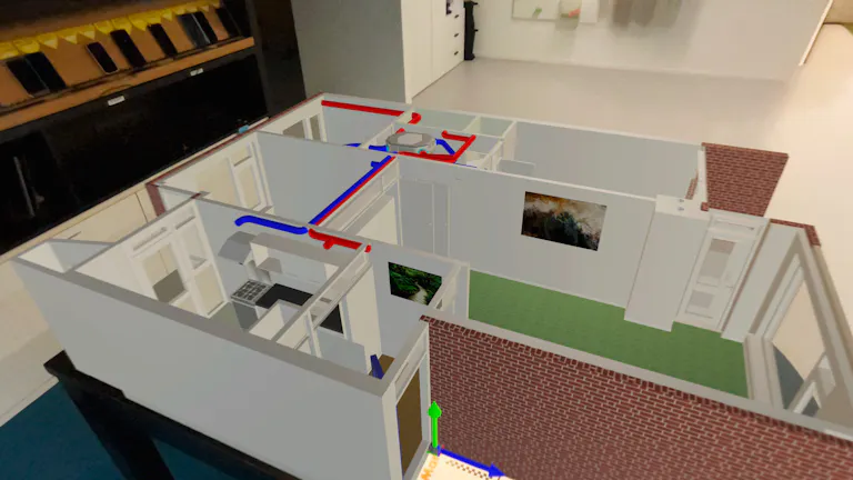 Gebouw virtueel op tafel geprojecteerd. Verschillende leidingen in een rode en blauwe kleur zijn in beeld.