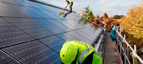 Men working on solar panels on a roof