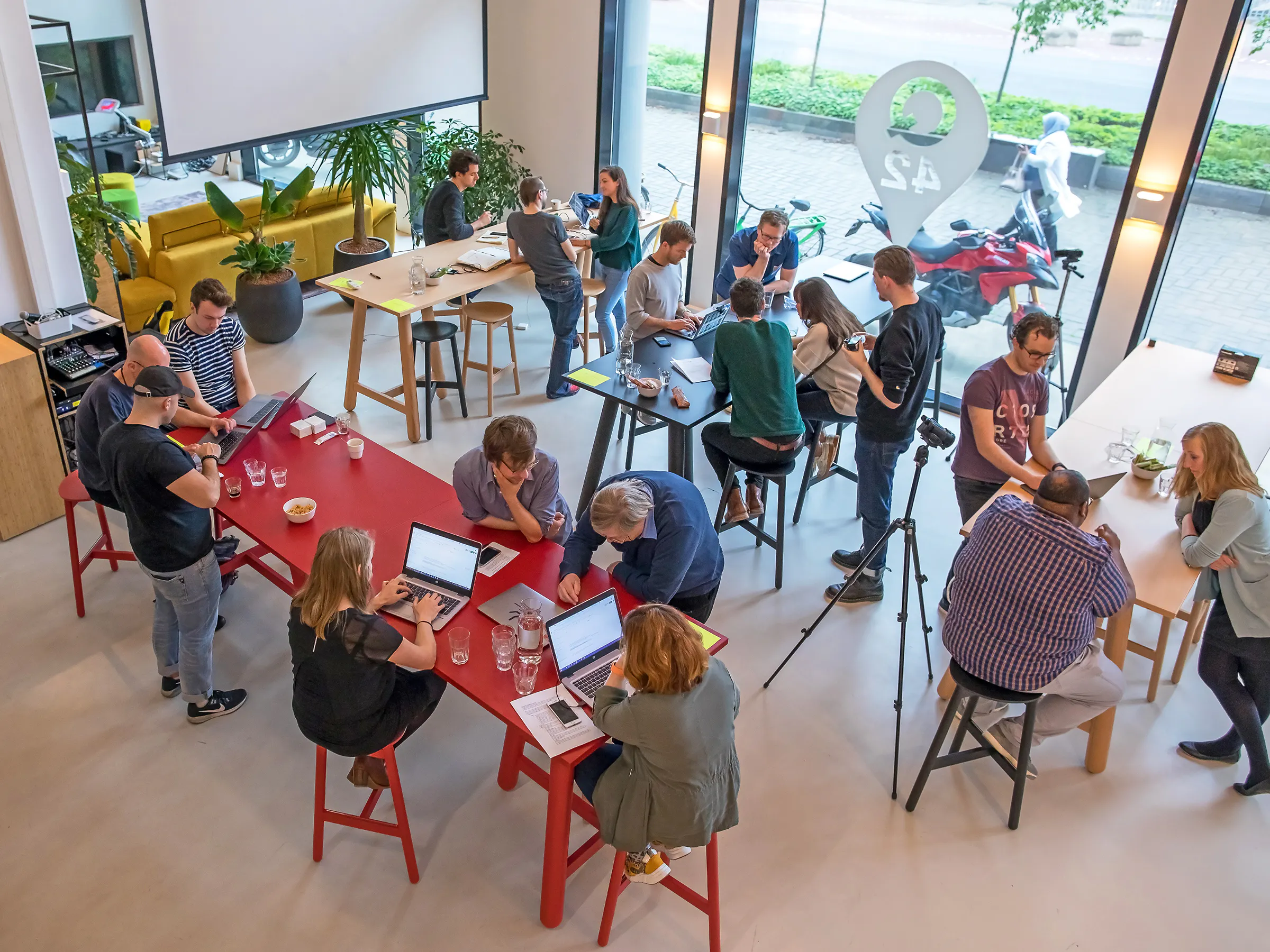 People standing at high tables in a room participating in a workshop.