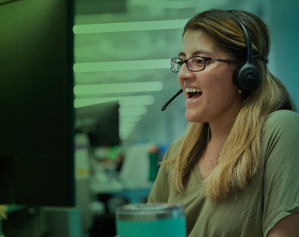 Lady smiling and talking to a member on a headset
