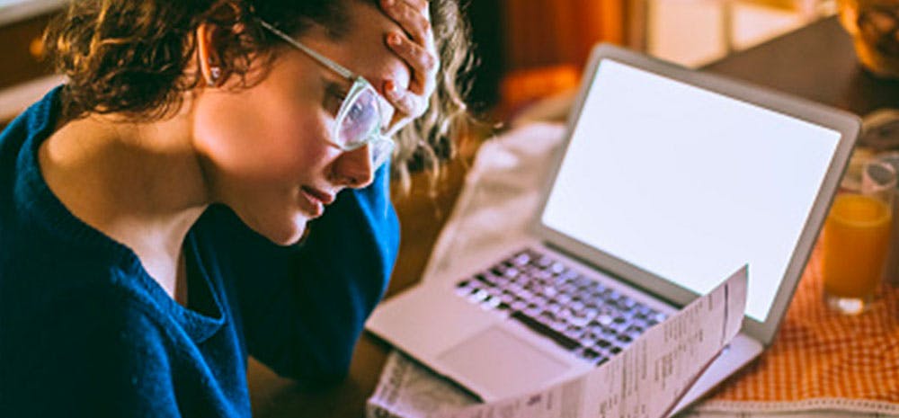 a frustrated woman looking at her medical bills. 