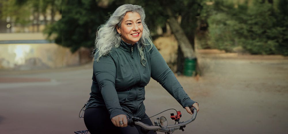 Lady riding her bike and smiling