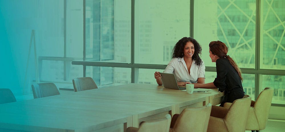 Women coworkers working together at a conference table in an office