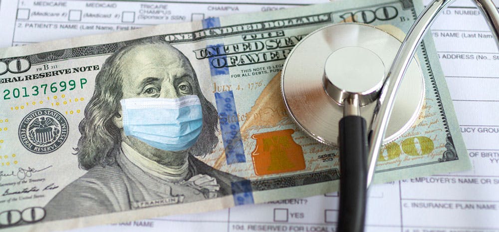 a stethoscope on-top of a 100 dollar bill. 