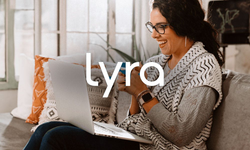 Lyra logo with lady smiling on her laptop
