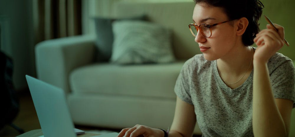 Woman looking at pc while holding a pencil