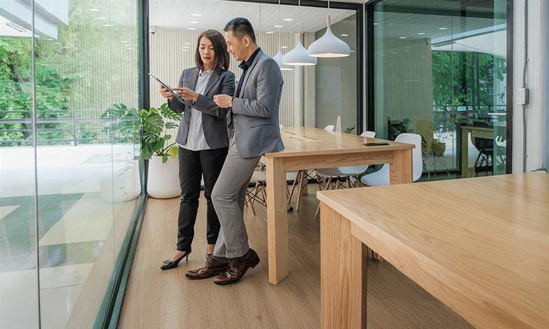 Two coworkers looking at a tablet together