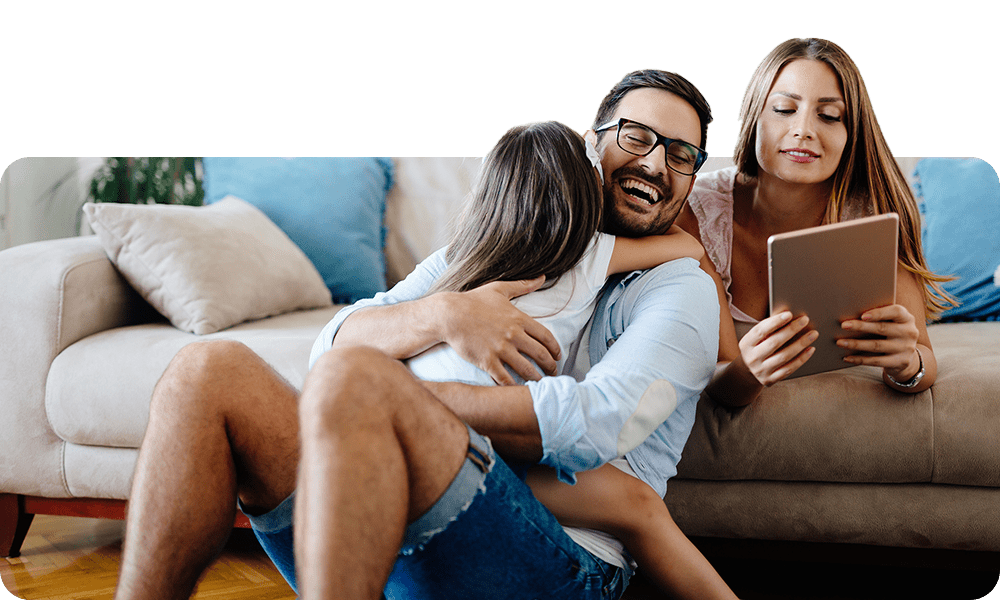 Family on couch smiling with tablet