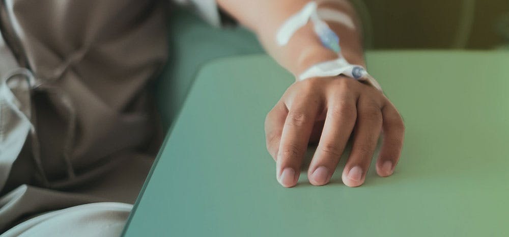 Patient with hand on table with IV placed