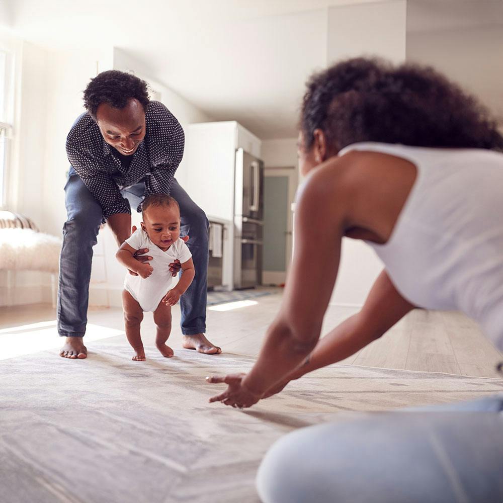 Mom and dad having their baby take their first steps