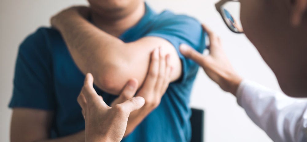 A doctor examining a patient's arm and joints